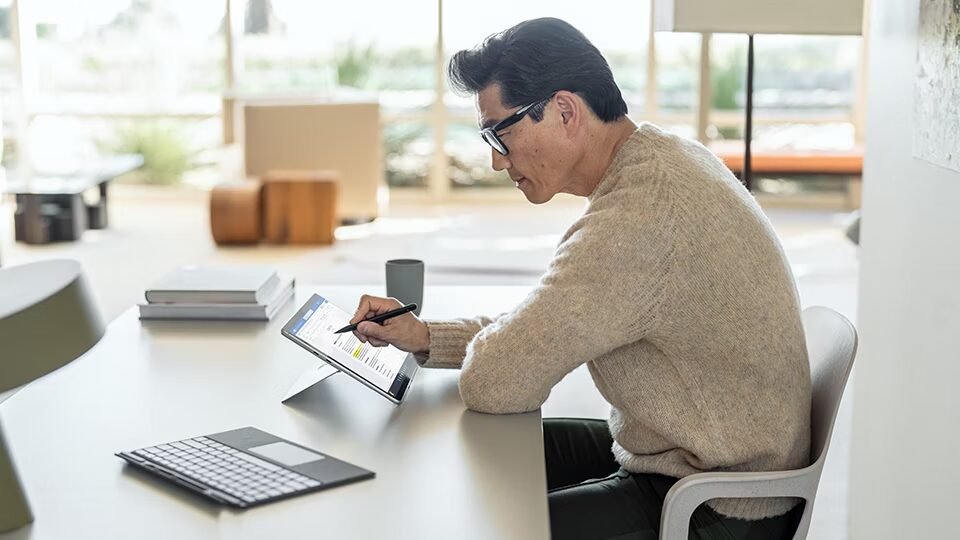 Business professional using a forest green microsoft surface pro 9 in a professional workspace